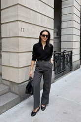 a lady wears a black blouse with grey wide leg pants